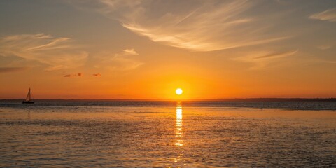 Obraz premium The sun setting over tranquil waters, emphasizing evening light and peaceful scene