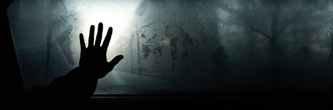 Person's hand on car window glass, emphasizing vehicle maintenance and safety inspection