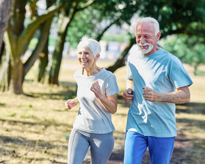 Smiling active mature senior couple jogging together in the park