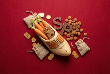 Dutch Holiday Sinterklaas background. Shoen Zetten. Zack van Sinterklaas. Children's shoes, carrots, gifts on red velvet texture background tio view. Copy space