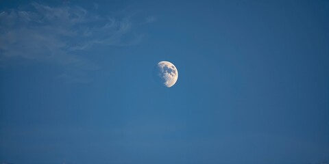 Close-up of the Half Moon against a clear blue sky, emphasizing celestial observation