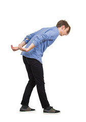 Side view young male student in stooped pose, leaning forward with his back curved and his arms bent behind him as he carries a heavy, invisible load or is in a position of cowering or physical strain