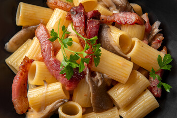 Mezzi rigatoni con guanciale e funghi, pasta italiana