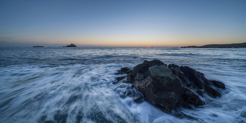 Waves crashing against rocks at dawn, coastal erosion risk, Earth Day