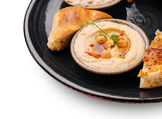 Delicious hummus and warm bread served on a black plate