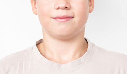 Fototapeta premium Close-up young boy’s face, soft contours of his jaw and neck, smooth skin with natural texture, soft lips, neutral expression, white background, studio lighting, teenage life, difficult age
