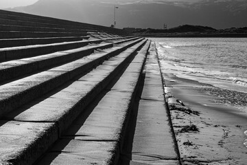 Concrete sea defence steps with strong shadows in black and white