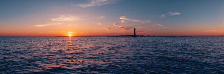 Obraz premium Oceanic sunset illuminating an Atlantic lighthouse, serving as a navigational aid at dusk, Earth Day