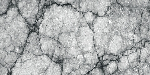 Detailed close-up texture of cracked grey asphalt pavement with visible aggregate and dark fissures creating a rough, weathered surface pattern