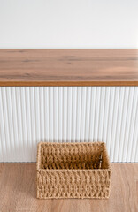 Woven Jute Basket on Wooden Floor with Modern Cabinet