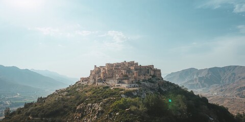 Aerial view of pink cherry blossom trees on a hillside with a winding hiking trail through a foggy spring forest, nature, seasonal change