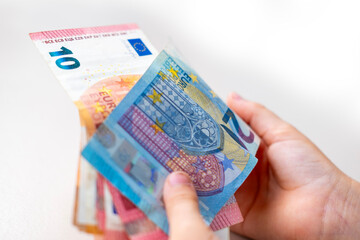 Little girl child, preschooler, primary school student, holding money, cash euros banknotes, hands close-up, cashing currency, financial freedom, innocence hidden mischief, early lessons about value