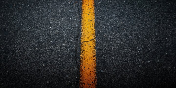 Asphalt road surface with yellow dash strip used for traffic lane marking, suitable for urban infrastructure planning
