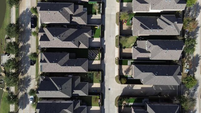 Two-story homes with small yards, driveways arranged along parallel streets, Flower Mound. Tree-lined sidewalks, curbside parking reflect area organized suburban planning, residential rhythm, TX