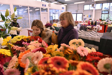 Mother and daughter shopping for flowers at indoor market