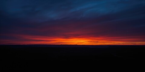 Twilight landscape featuring a dark blue sky illuminated by an orange sunset glow, suitable for background or layout design, Earth Day