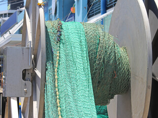 Green fishing net on a spool on a trawler. Winch