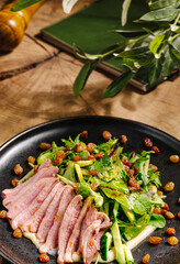 Delicious salad with sliced meat presented on a rustic wooden table