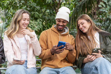 Friends laughing together while sharing something on the phone