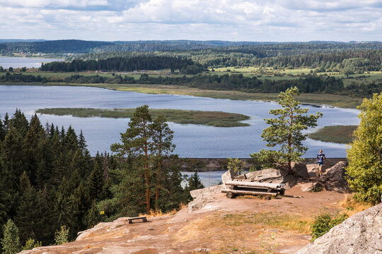 Panoramic view from the top of the cliff to the lake surrounded by forests and fields. Viewpoint in Sortavala. Nature of the Republic of Karelia. North.