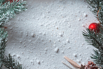 Winter holiday background featuring decorative Christmas wreath frame, snow covered fir branches,...