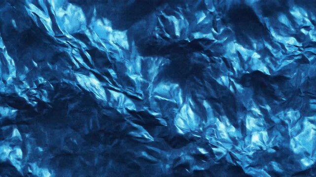 Close-up of textured blue crumpled foil with shiny reflective surfaces.