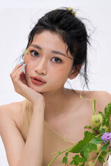 Close-up of the woman's lips gently touching a purple flower.