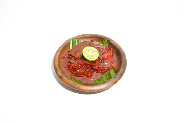 Indonesian sambal tomat tomato chili paste with lime in clay bowl with banana leaf