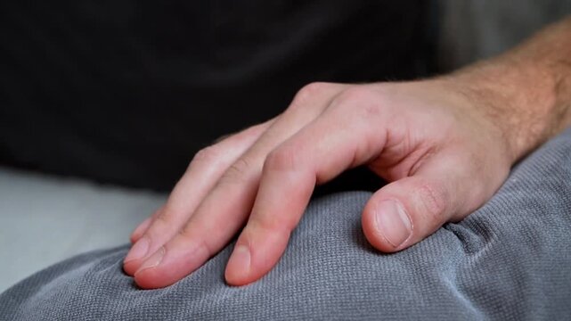 Extreme close-up hand nervous finger tapping on couch fabric fast motion anxiety stress OCD tic restlessness fidgeting small motor activity evening warm light