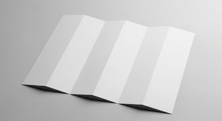 White paper folded in zig zag pattern on a gray surface.