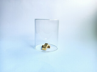 A set of small gold bars enclosed under a transparent glass dome, symbolizing security, protection, scarcity, and preserved wealth on a clean light blue backdrop.