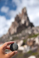 Traveler Holding Carved Stone with Mountain Peak in Background