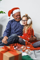 Loving moment between generations as grandfather and his granddaughter share playful holiday scene....