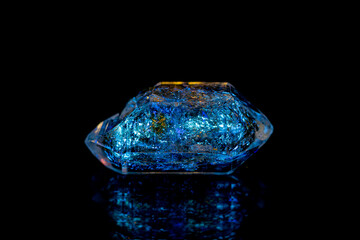 Closeup fluorescence glowing petroleum quartz (Enhydro/EnPetro Quartz)(quartz with hydrocarbon inclusions) under UV light on dark background