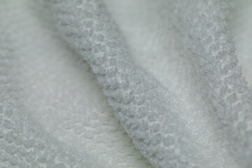 Extreme closeup of a fresh white terry cloth towel. Soft, fluffy texture with gentle folds. Perfect background for spa, cleanliness, or wellness concepts.