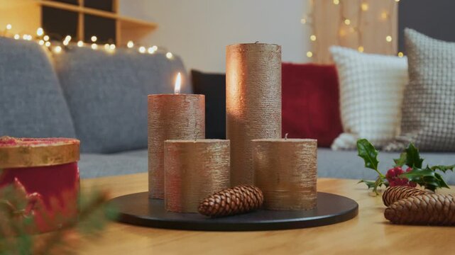 Christmas Home Decorations &ndash; Modern Advent Arrangement with Lit Golden Candle on Wooden Coffee Table
