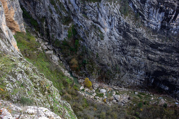 Steep canyon drop revealing rocky basin below