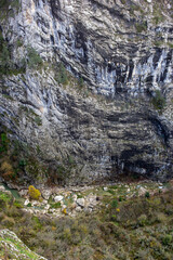 Tall vertical canyon wall with deep natural rock cavity