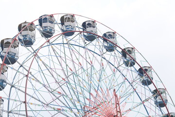 Closeup of multi-coloured Giant Wheel during Dussehra Mela in Delhi, India. Bottom view of Giant Wheel swing. Ferris wheel with colourful cabins during evening time.