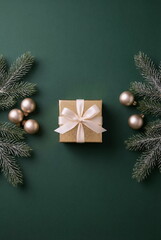 Minimalist Christmas or New Year background with gift box and decorations on dark green backdrop. empty copy space for text.holiday and celebration concept for postcard or invitation. top view 