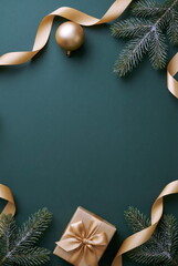Christmas or New Year frame decorations gold colors on dark green background with empty copy space for text. holiday and celebration concept for postcard or invitation. top view 