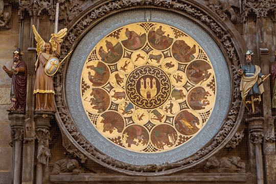 Detail of the astronomical calendar dial of the Prague Orloj in Prague, Czech Republic, featuring the painted zodiac and seasonal scenes surrounded by ornate medieval sculptures.