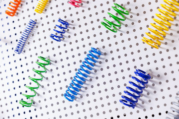 Colorful springs display on perforated background with diagonal arrangement
