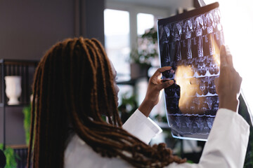 African female doctor analyzing x-ray in a medical office setting
