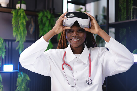 Portrait happy African female doctor exploring virtual reality technology in medical setting, innovation VR with AI assistant