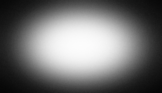 Black and white radial vignette gradient background. Central light glow. Soft blurred edges. Subtle noise grain texture. Smooth grayscale fade. Minimal monochrome light burst effect. PNG