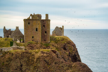 Dunnottar castle ruins standing on coastal cliff in scotland