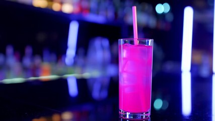 A pink beverage in a glass, ice cubes, and a straw, lit with neon blue bar lighting - Powered by Adobe