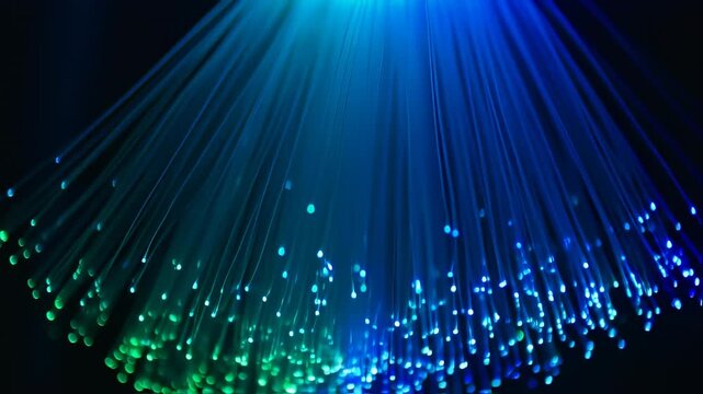 A close-up view of illuminated blue and green fiber optic cables against a dark background