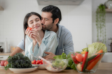Romantic young couple preparing fresh vegetables together in the kitchen.